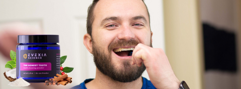 A picture of a man brushing his teeth with a jar of The Honest Tooth in the corner