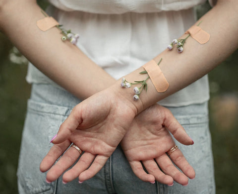 plants attached to woman's arm with bandaids