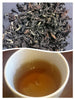 silvery dry tea leaves next to a cup of brewed choicest fancy silvertip oolong