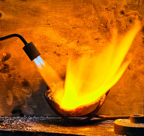 Melting gold in a crucible before casting into a ring.