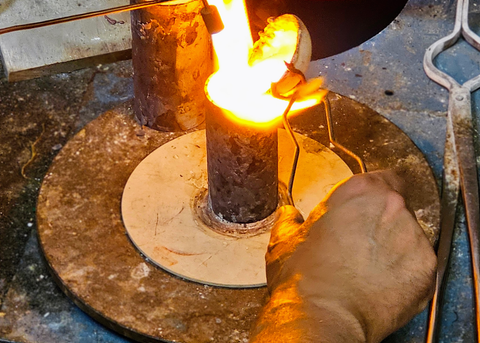 Casting gold into a mold flask.