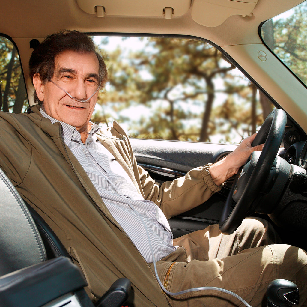 elder sit in car with portable oxygen concentrator