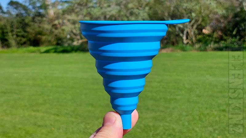 Holding a Blue Silicone Foldable Funnels for all Herbal Infusions NZ