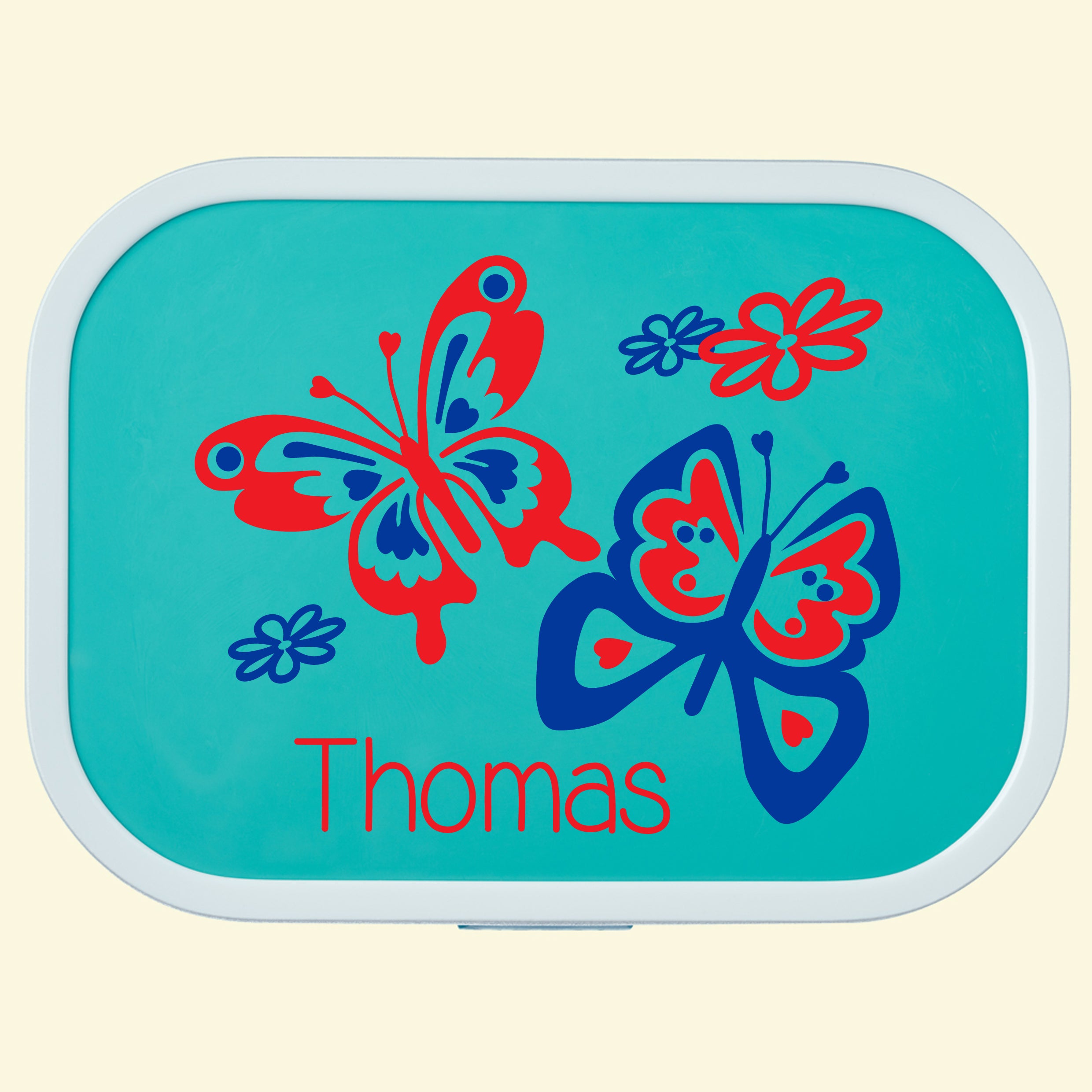 Turquoise campus lunch box with a butterfly design and the name Thomas