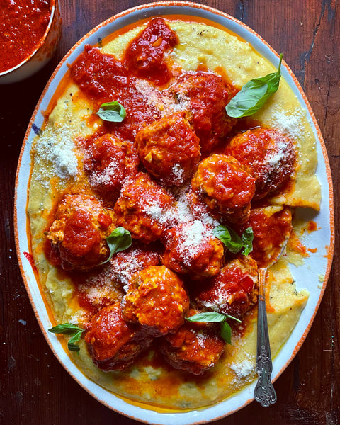 Polenta and turkey meatballs with red sauce on a platter