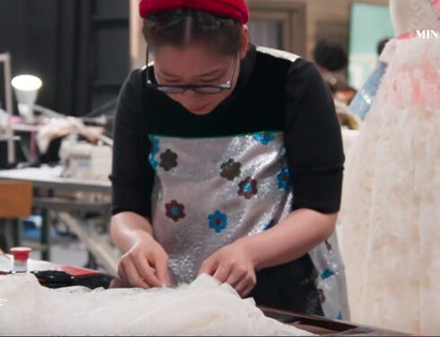 An image of designer Minju Kim at work on some textiles