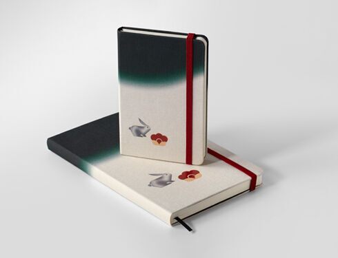 An image of Minju Kim's Moleskine notebook, with a green and white cover featuring a rabbit design
