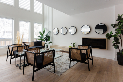 Living room with bamboo chairs, green plants, and natural lighting