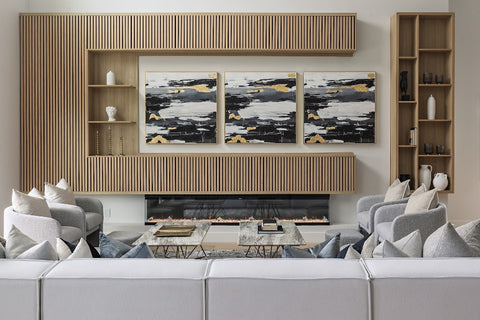 Gold cabinets in a living room with grey couches