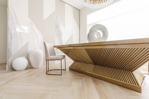 Designer gold table with white chair and white walls