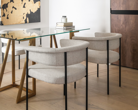 Two white chairs seated around square glass table with wood legs