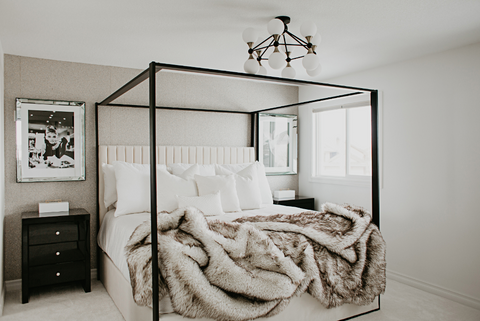 Bed with plush throw blanket and vintage prints on wall