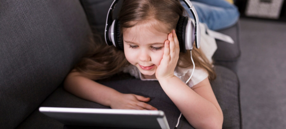 Pige kigger tablet med høretelefoner med ledning