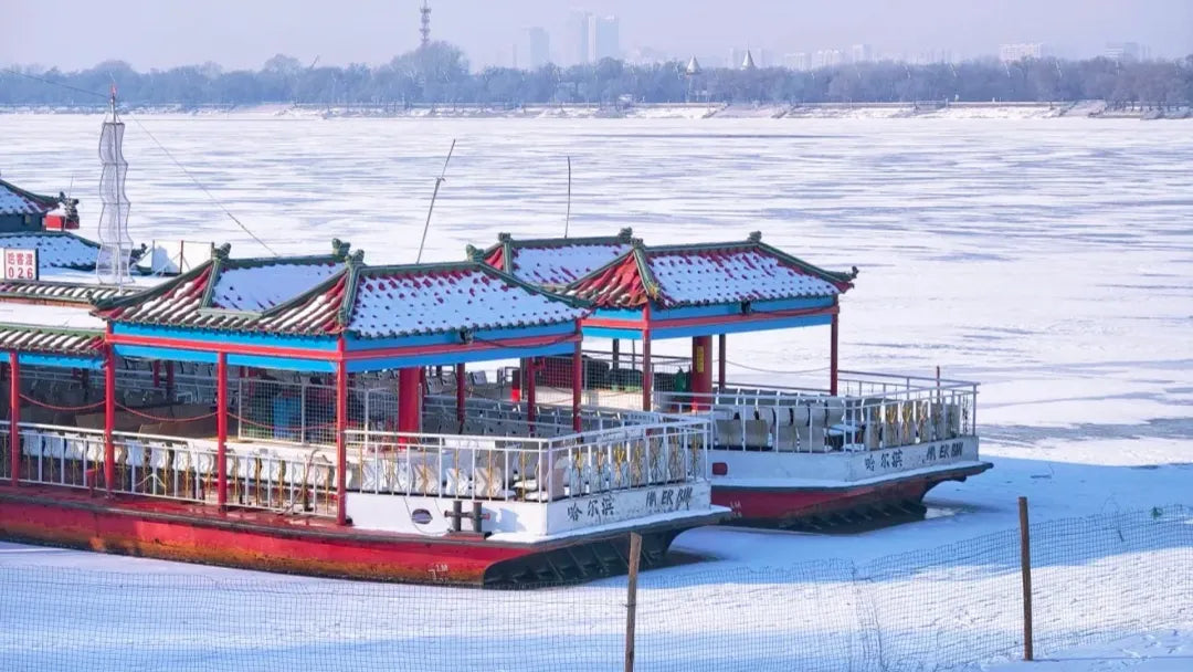 Serene frozen river with snow-covered Chinese-style boats during Greater Snow (Daxue).