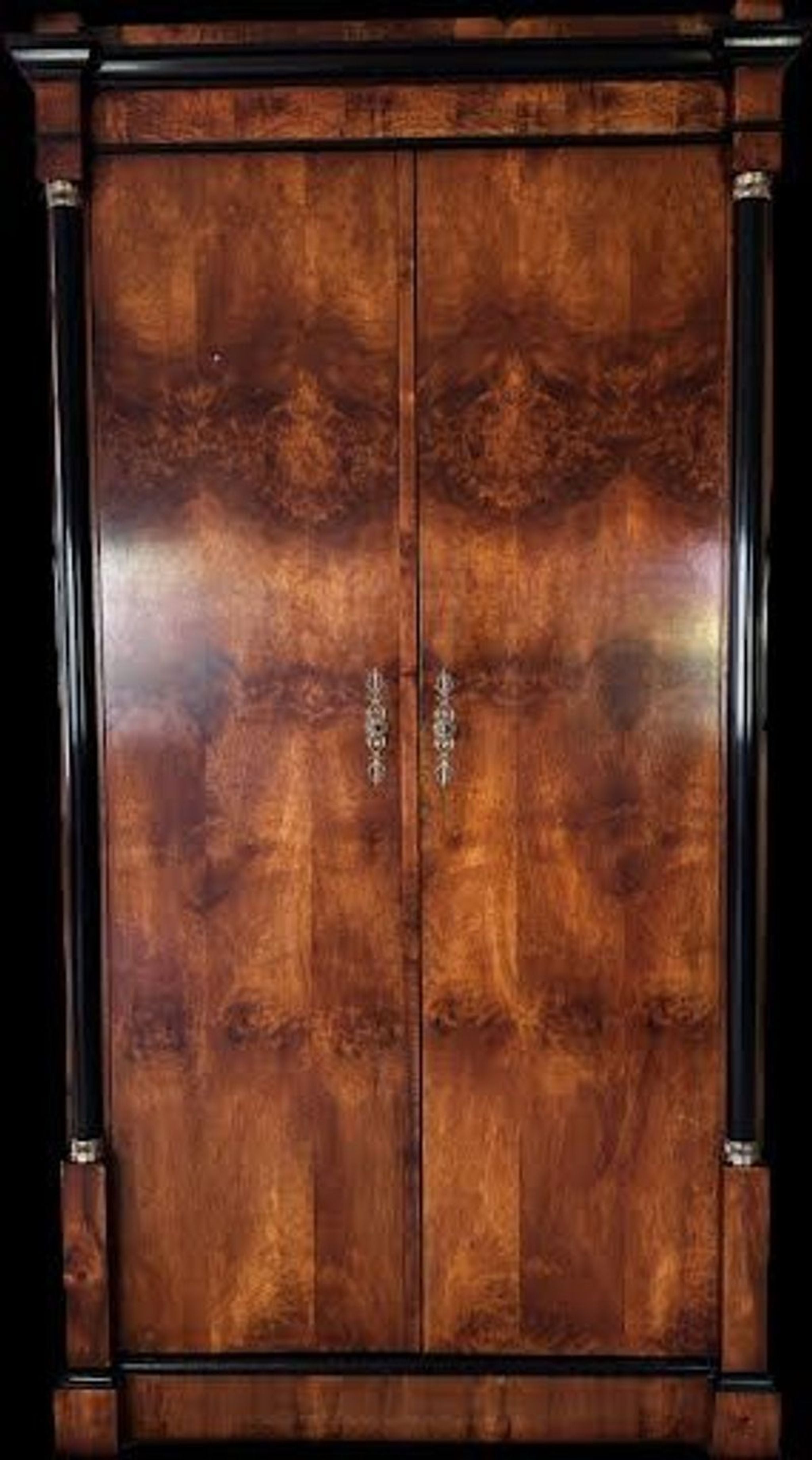 Darkened image featuring a Century Furniture burlwood armoire, closed, highlighting wood grain details.