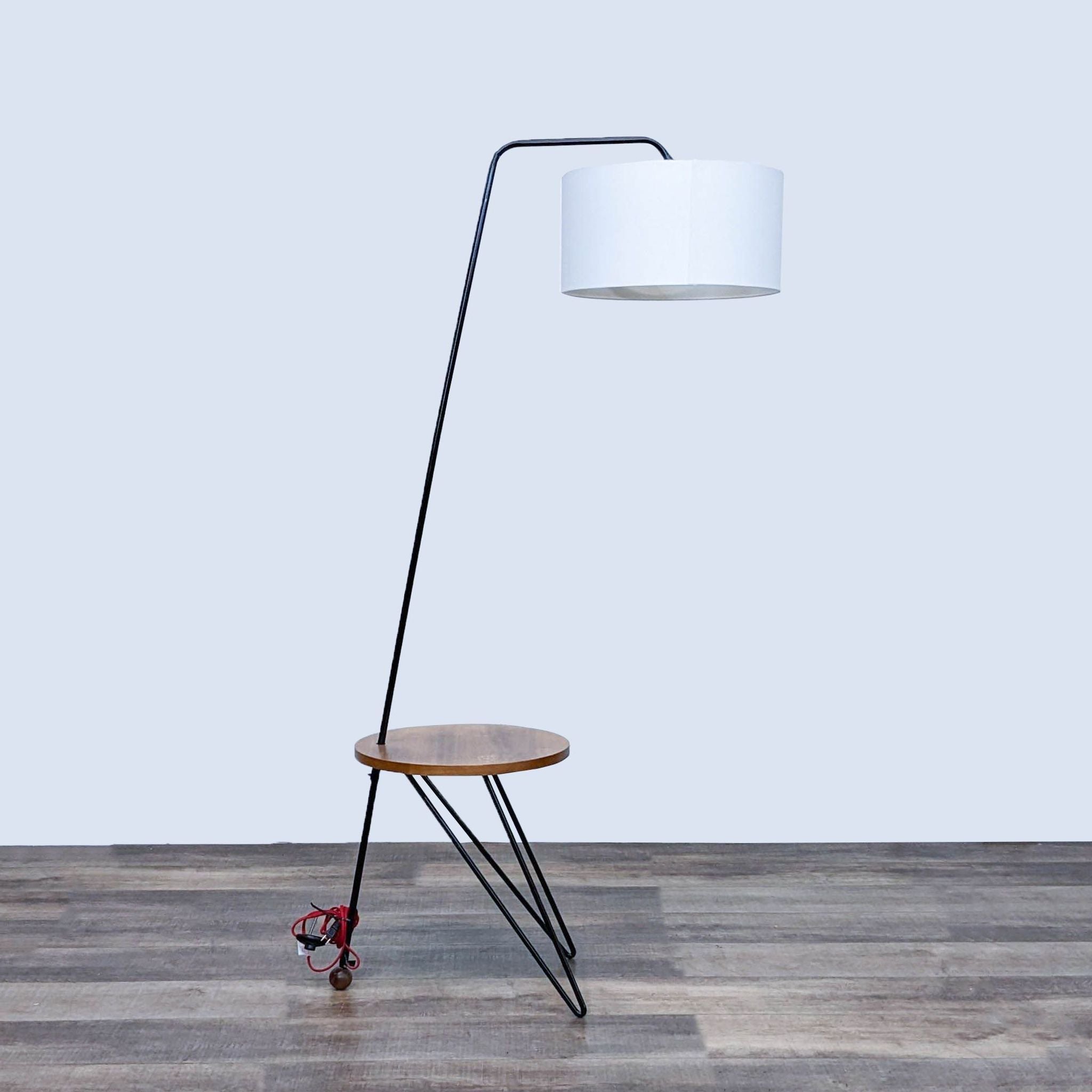 Reperch brand modern floor lamp with white shade and angular black frame incorporating a wooden shelf.