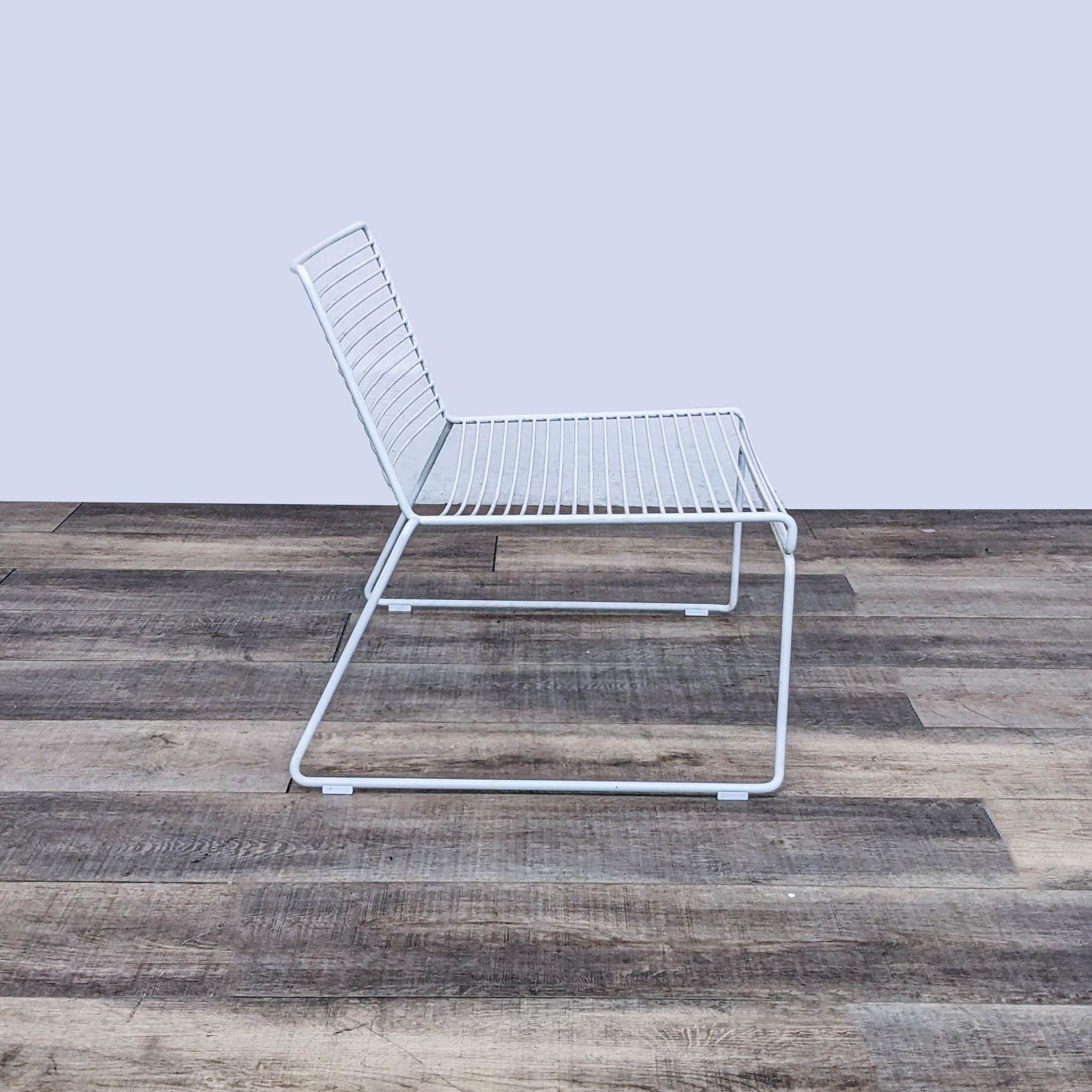 Design Within Reach's Hee lounge chair with a white powder-coated steel frame on a wooden floor.