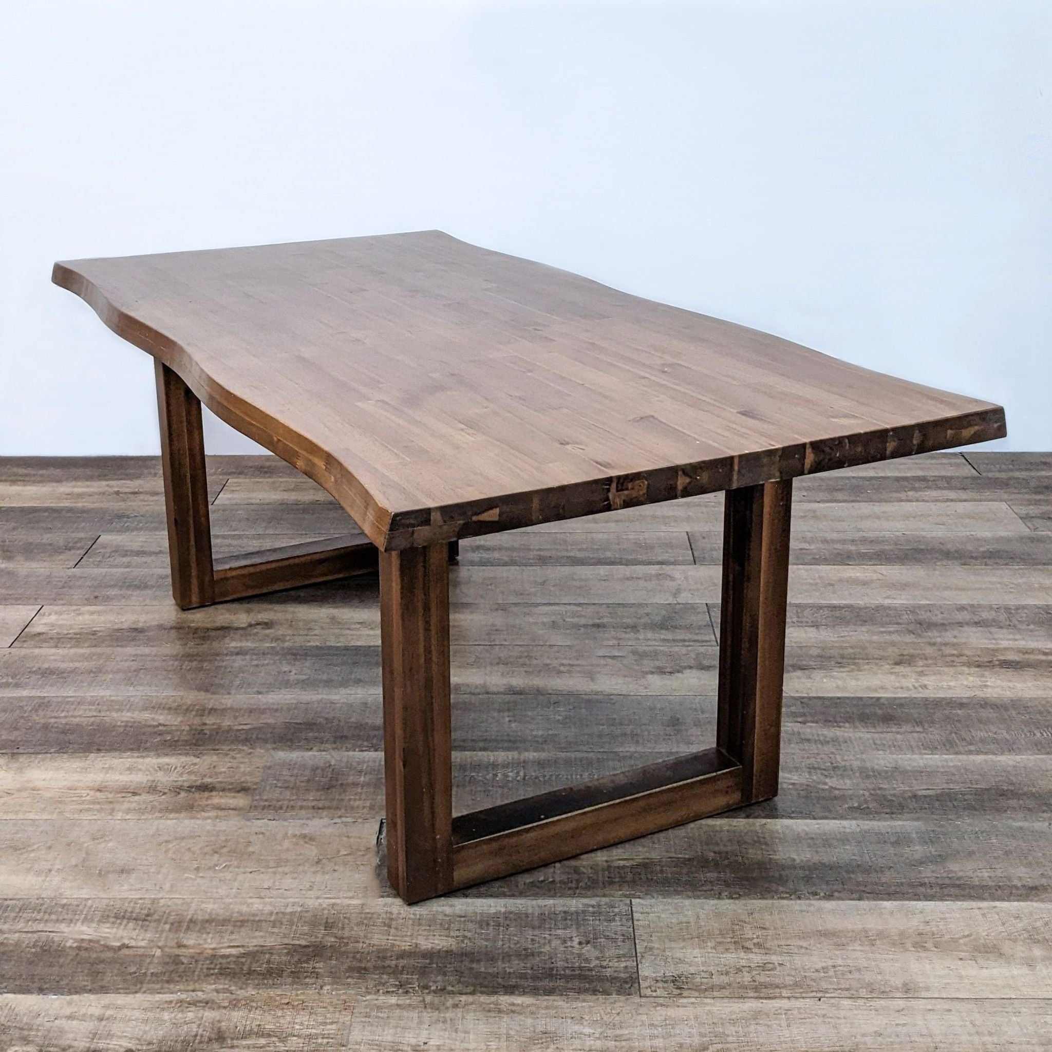 Transitional Reperch dining table showcasing a natural edge wooden top and sturdy sled base.