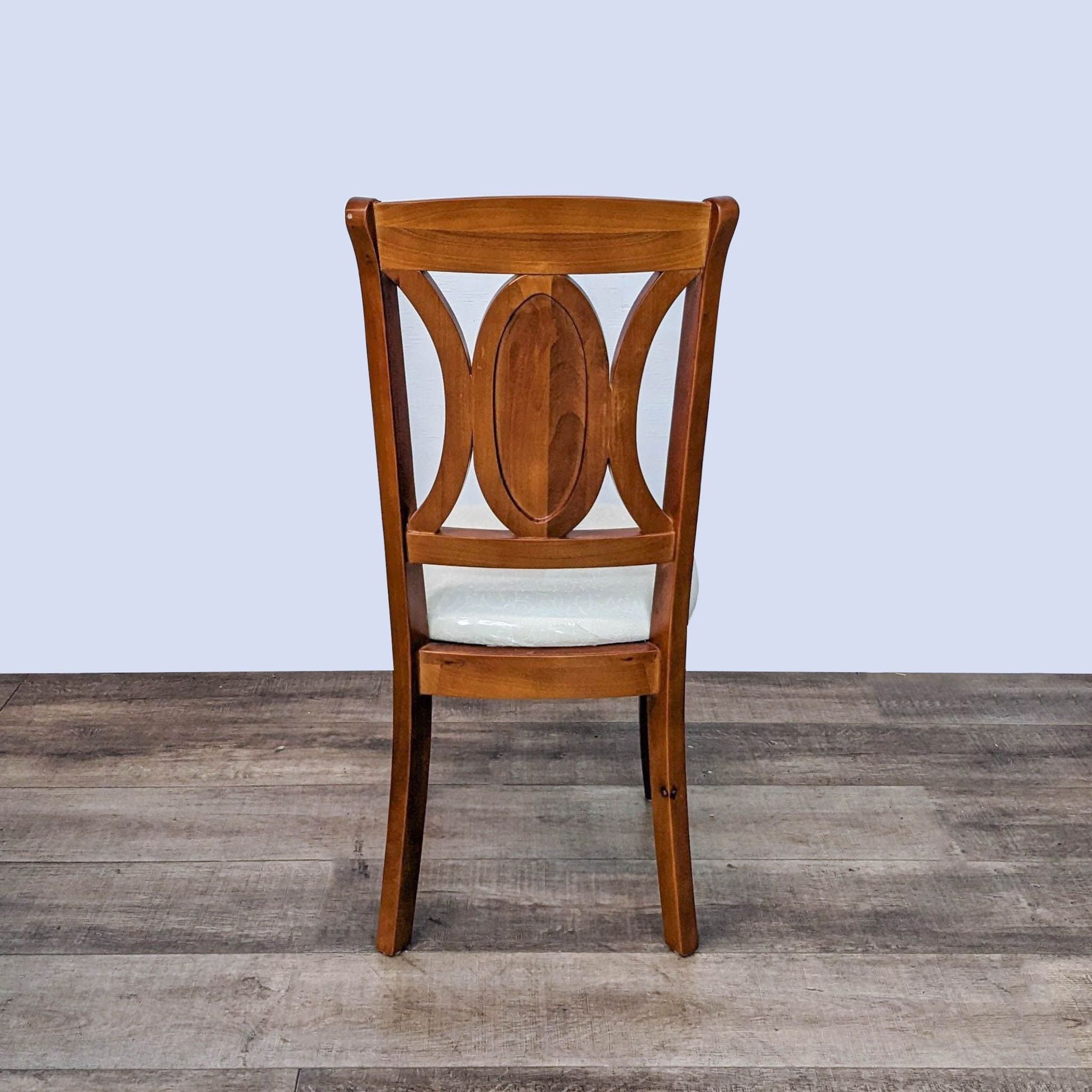 Reperch contemporary dining chair with wood frame and cream upholstered seat.