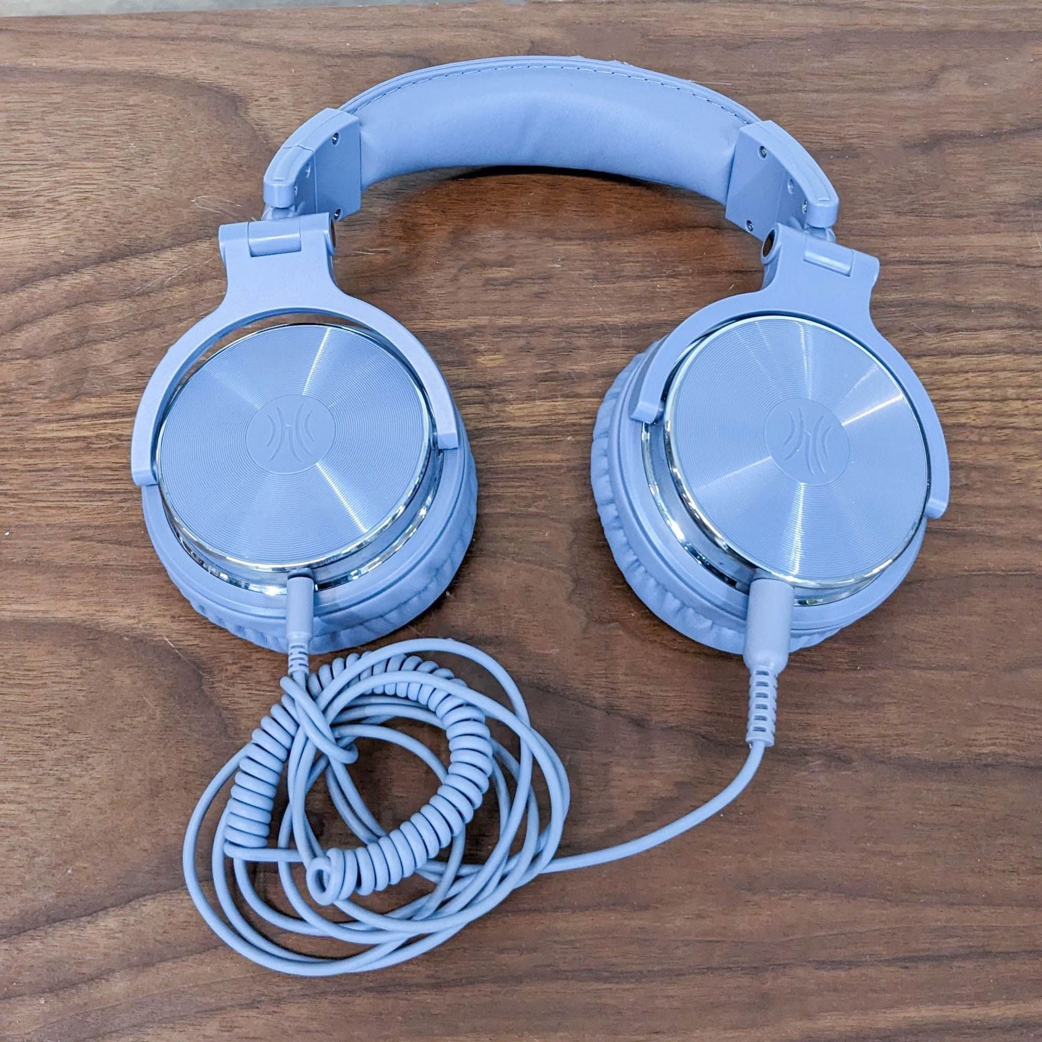 Top view of OneOdio closed-back headphones with L/R indicators inside earpads, coiled cord attached.