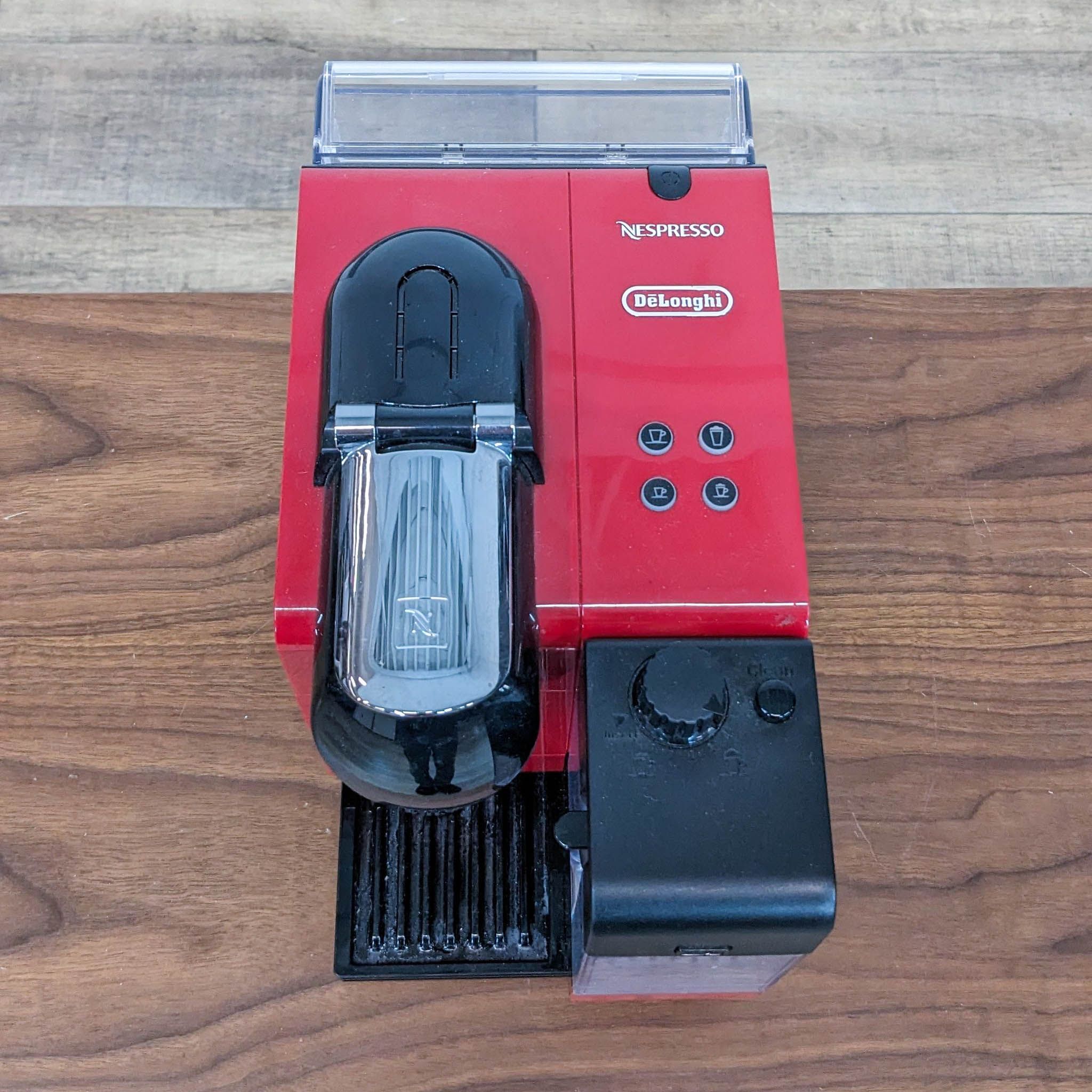 Top view of the DeLonghi EN520 coffee maker with Nespresso branding, touch buttons, and milk frother on wood surface.