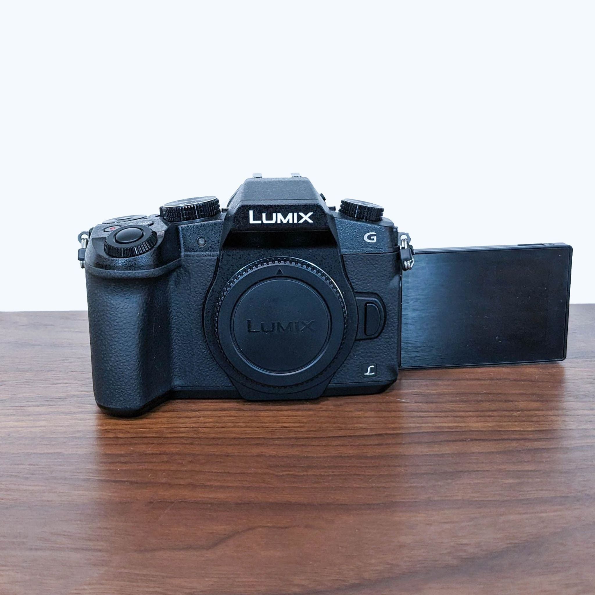 3. Side view of the LUMIX G Mirrorless Camera with a fully articulated screen extended to the side against a wooden background.