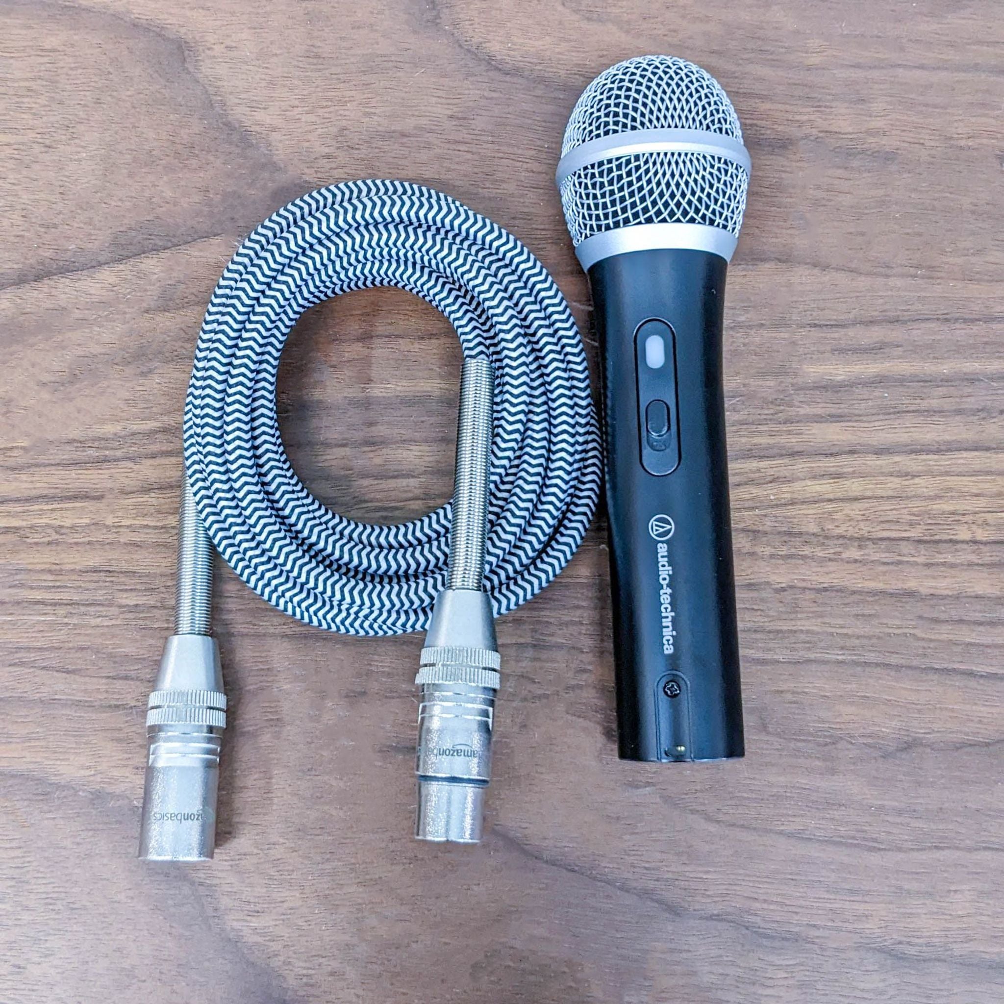 Audio-Technica microphone with XLR connectors and braided cable on a wooden surface, ideal for recording and streaming.