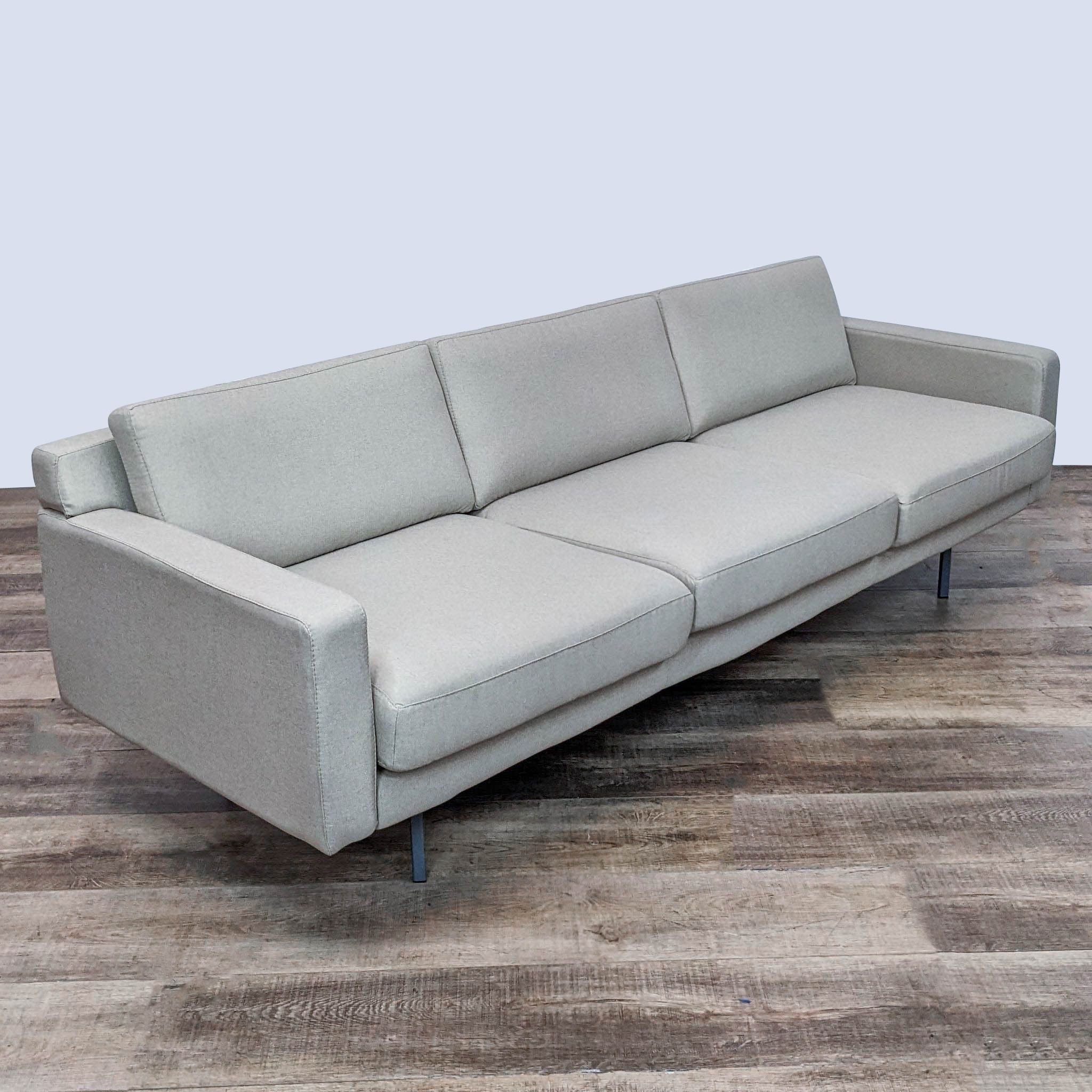 Rowe Furniture 3-seat minimalistic sofa with square arms and metal feet, shown in profile view on wooden floor.