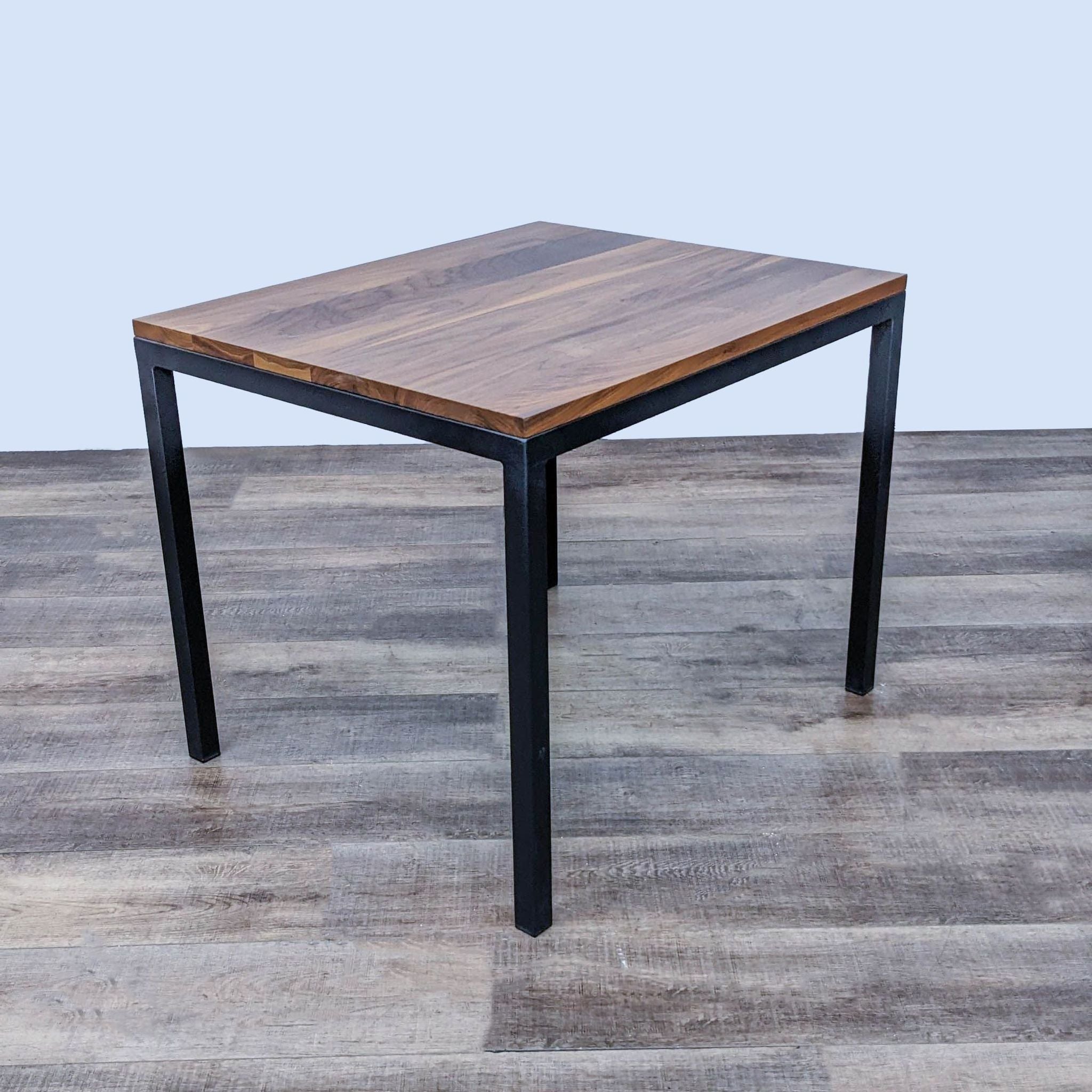 Room & Board brand Parsons dining table with solid walnut surface and welded steel legs.