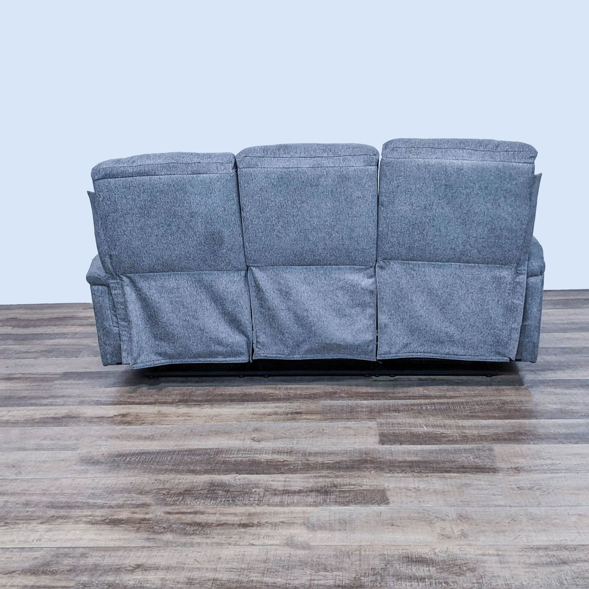 Alt text 2: Side view of a gray high-back dual reclining Living Spaces sofa showcasing the extended footrest and plush side padding.