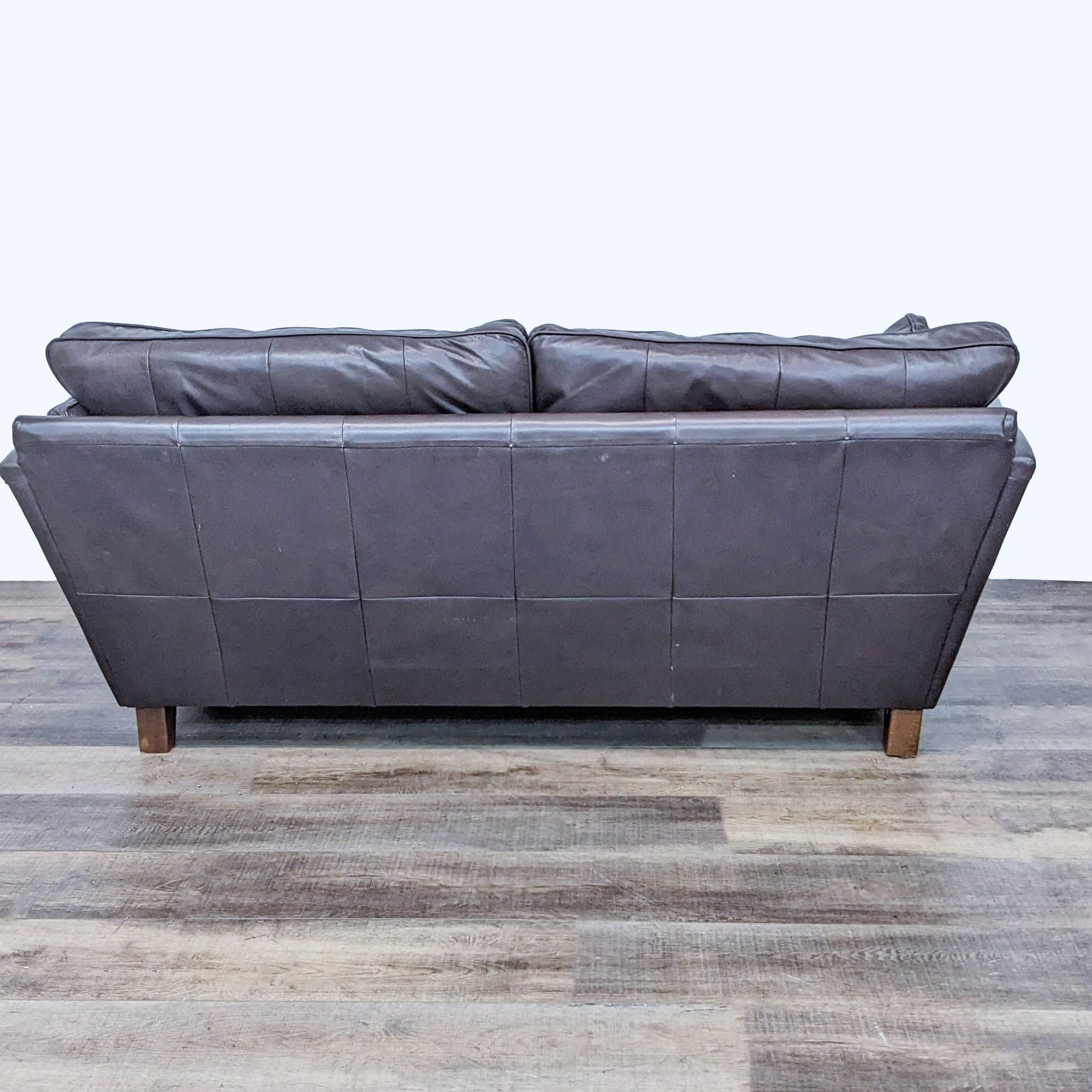 Marks & Spencer 3-seat leather sofa showcasing back and side angle, with flared arms and wood feet.