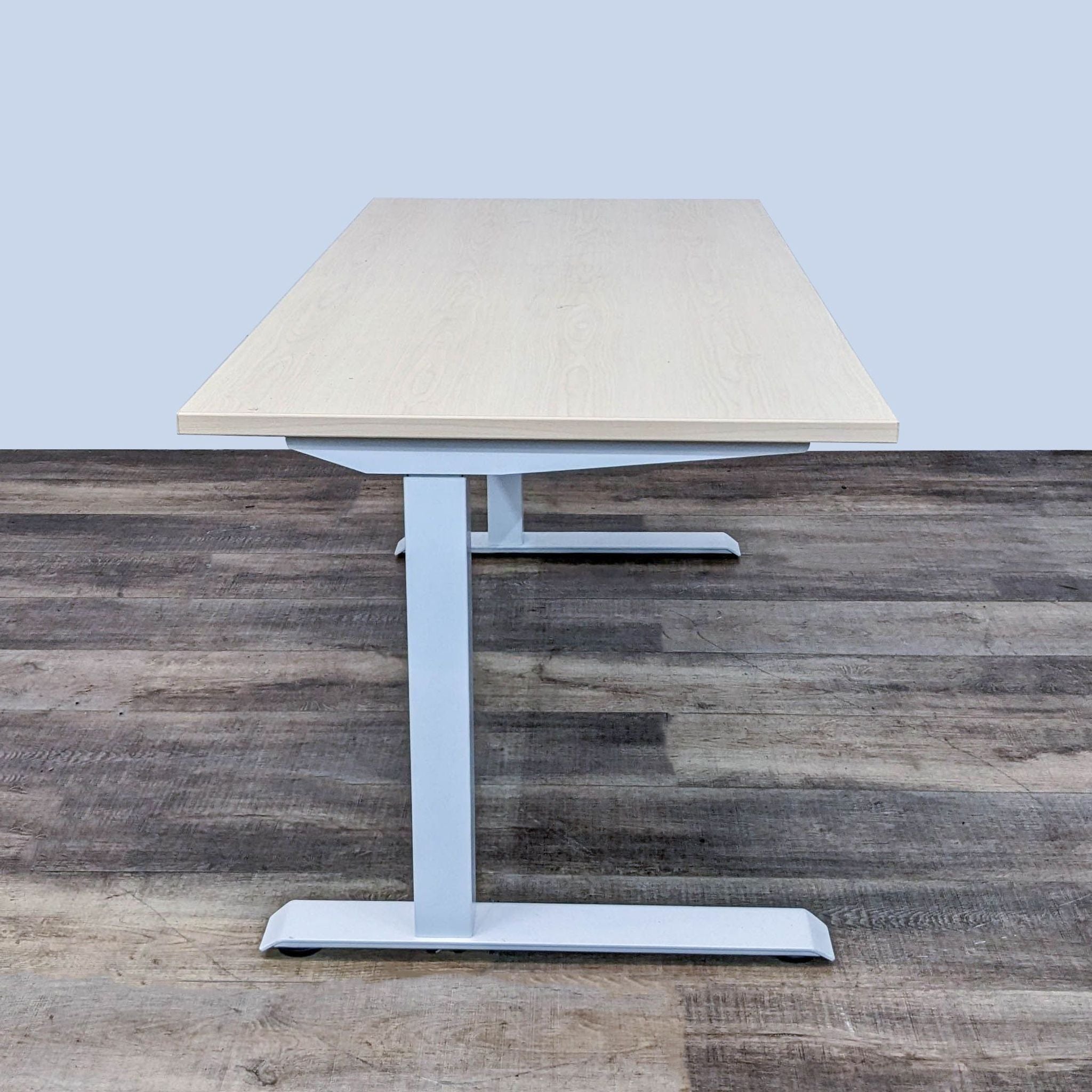 AMQ brand electric height-adjustable standing desk with oak finish tabletop and dual-motor lift system.
