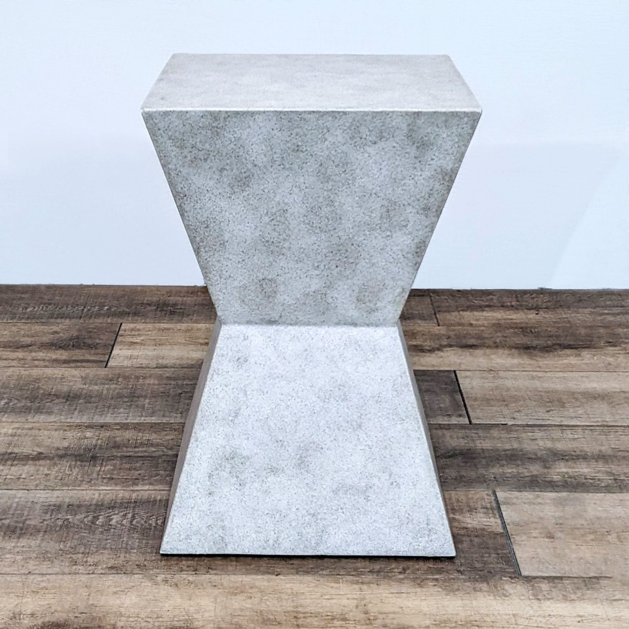 Modern Reperch end table mimicking concrete, positioned diagonally on hardwood flooring.