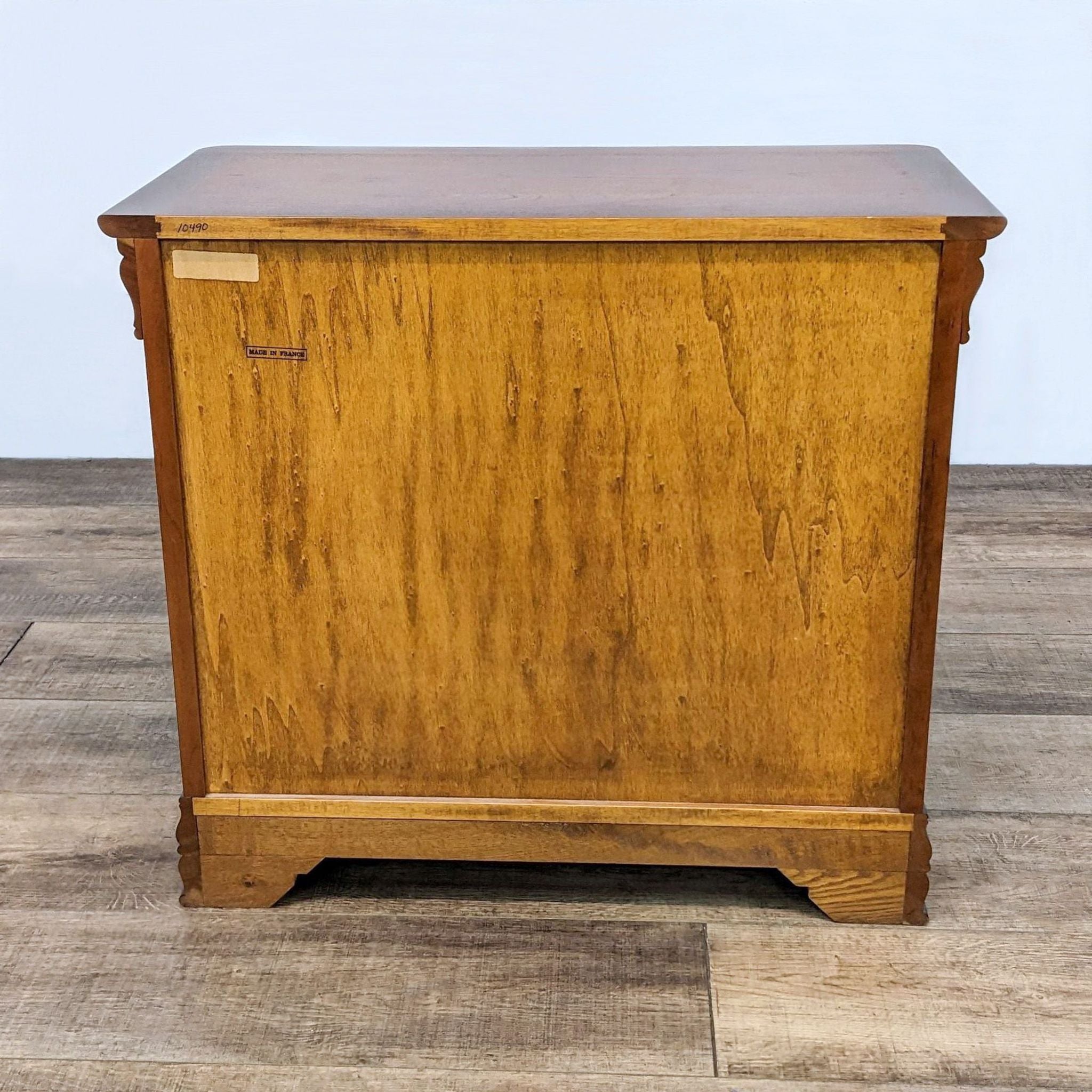 Reperch end table with heavy molding and closed raised panel doors viewed from front on a laminate floor.