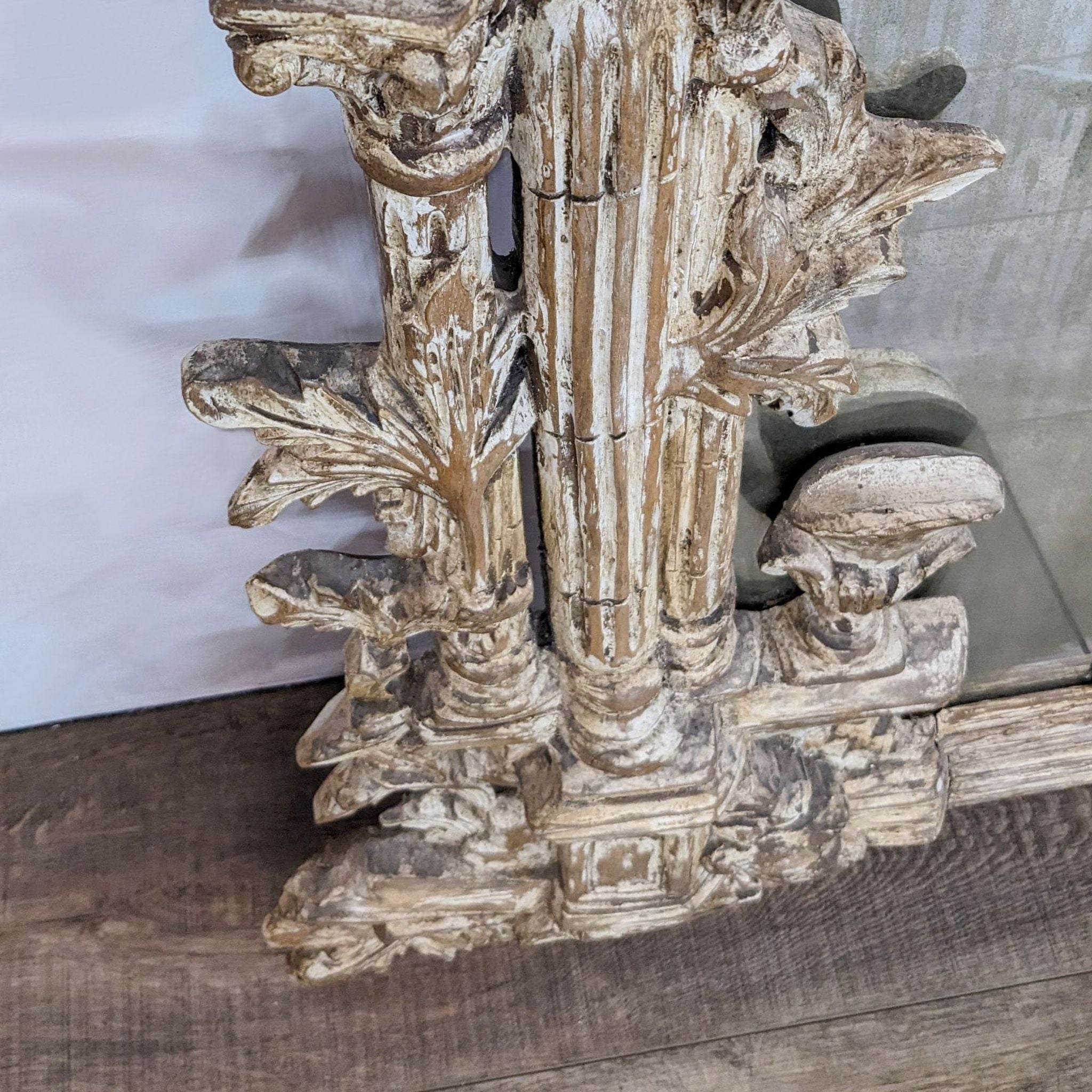 Close-up of a Reperch antique large mirror with detailed carved wooden frame and part of the mirrored panes visible.