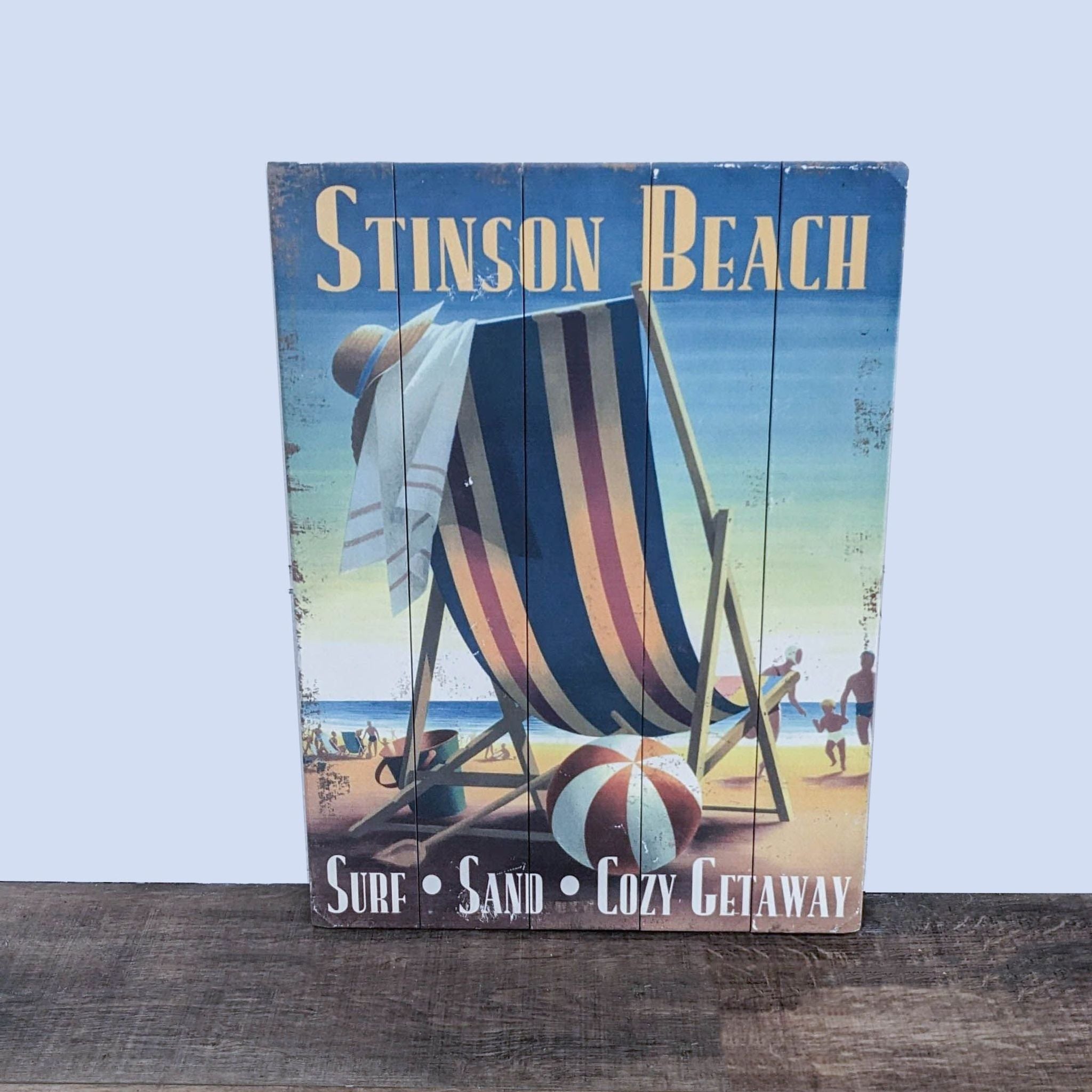 Alt text 1: A colorful art print on wood depicting a beach scene with a striped beach chair and umbrella, titled "Stinson Beach."