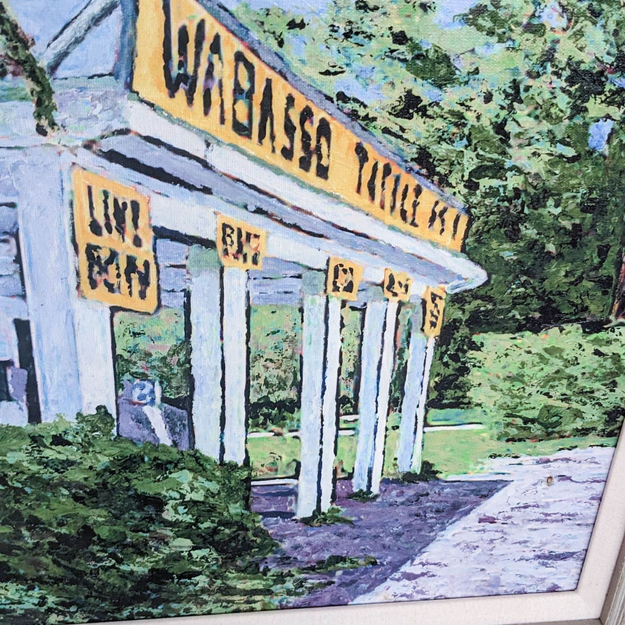 Back view of a framed painting depicting Wabasso Tackle Shop, with paper backing and hanging wire.