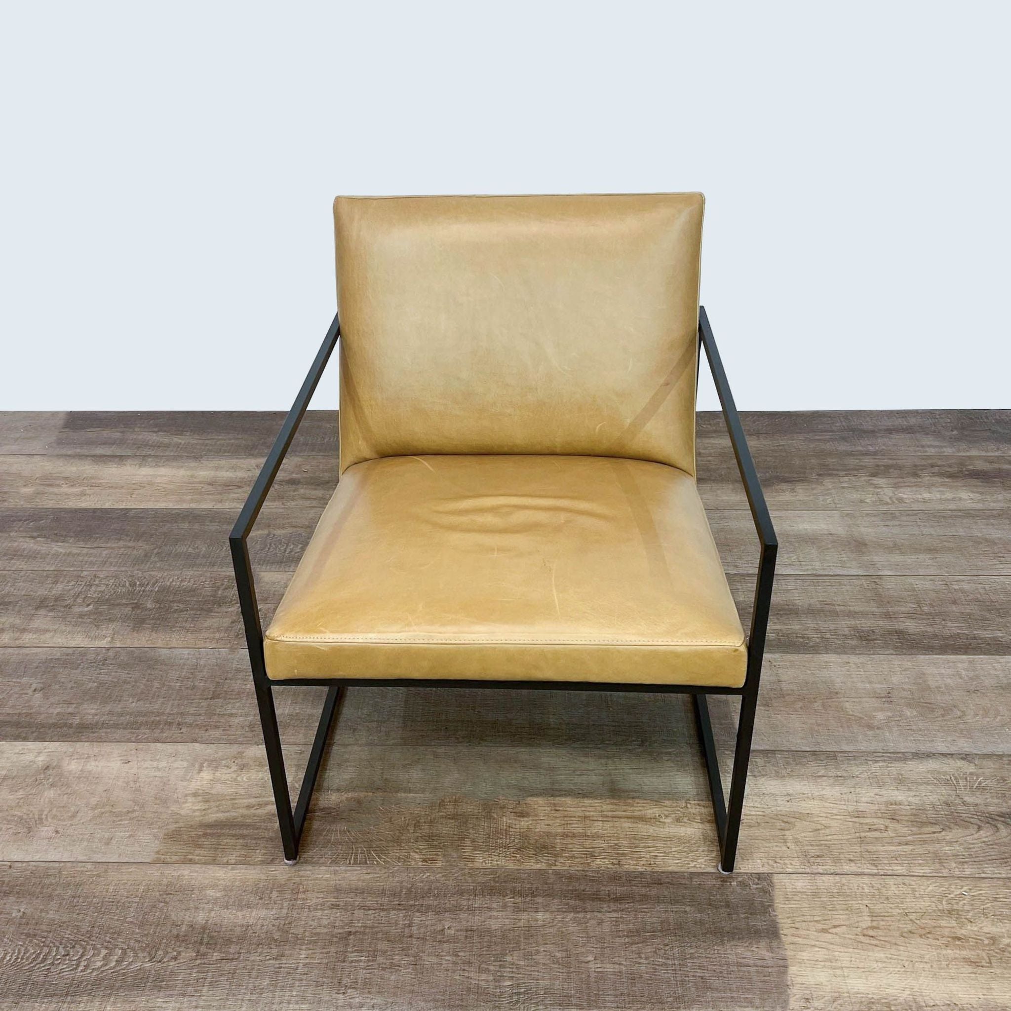 Room & Board Novato armchair with thin-profile leather seat and natural steel frame on a wooden floor.