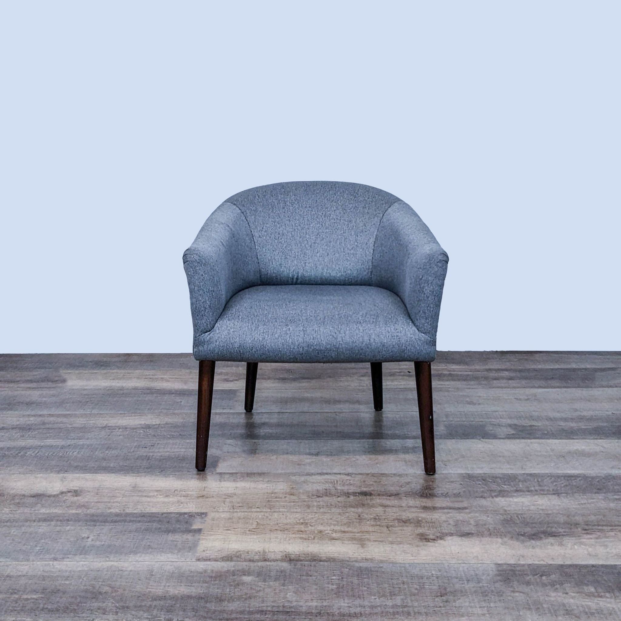 Reperch mid-century lounge armchair with barrel back and dark gray upholstery, on tapered wooden legs.