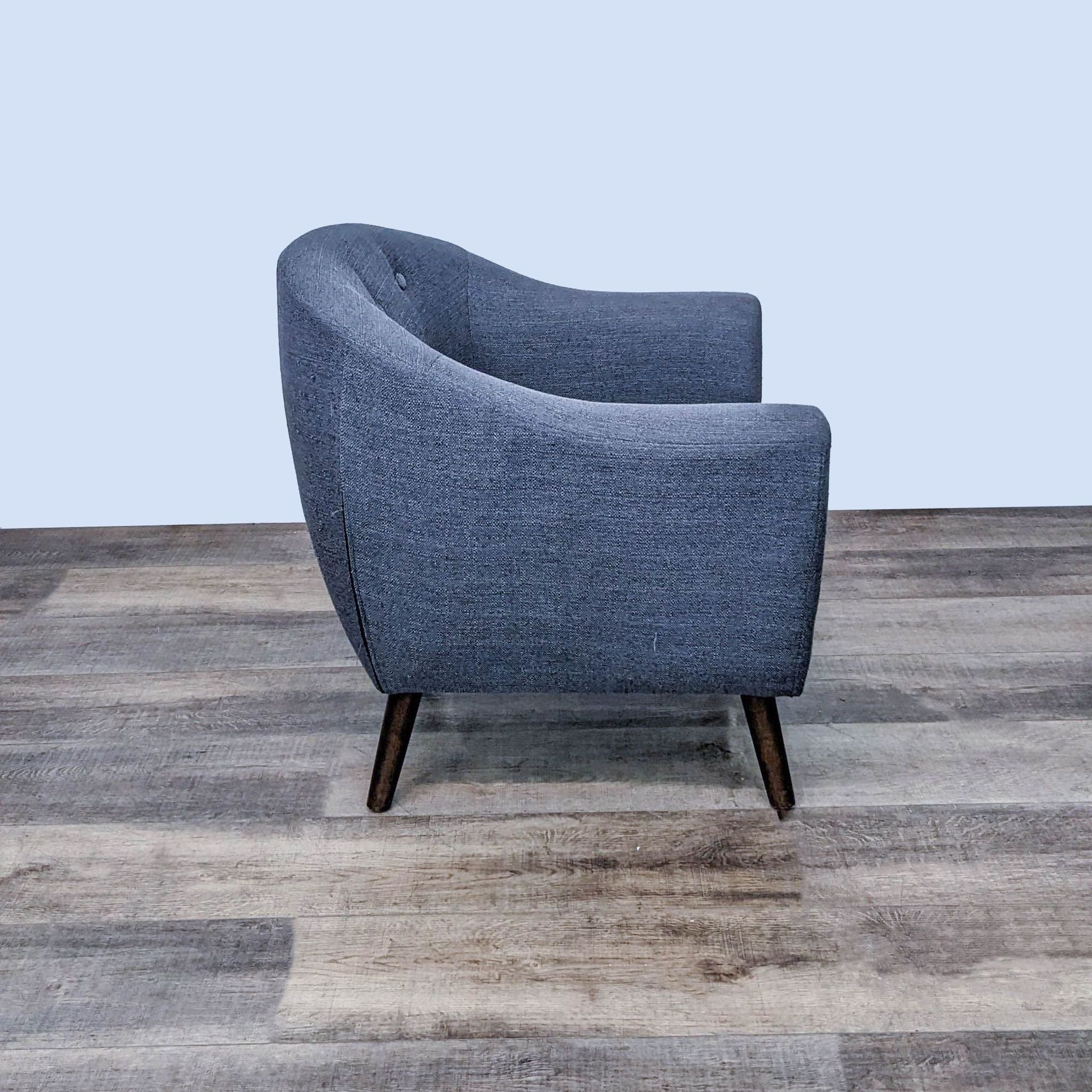Reperch branded mid-century upholstered chair, shown from the side and back, highlighting the curved shape.