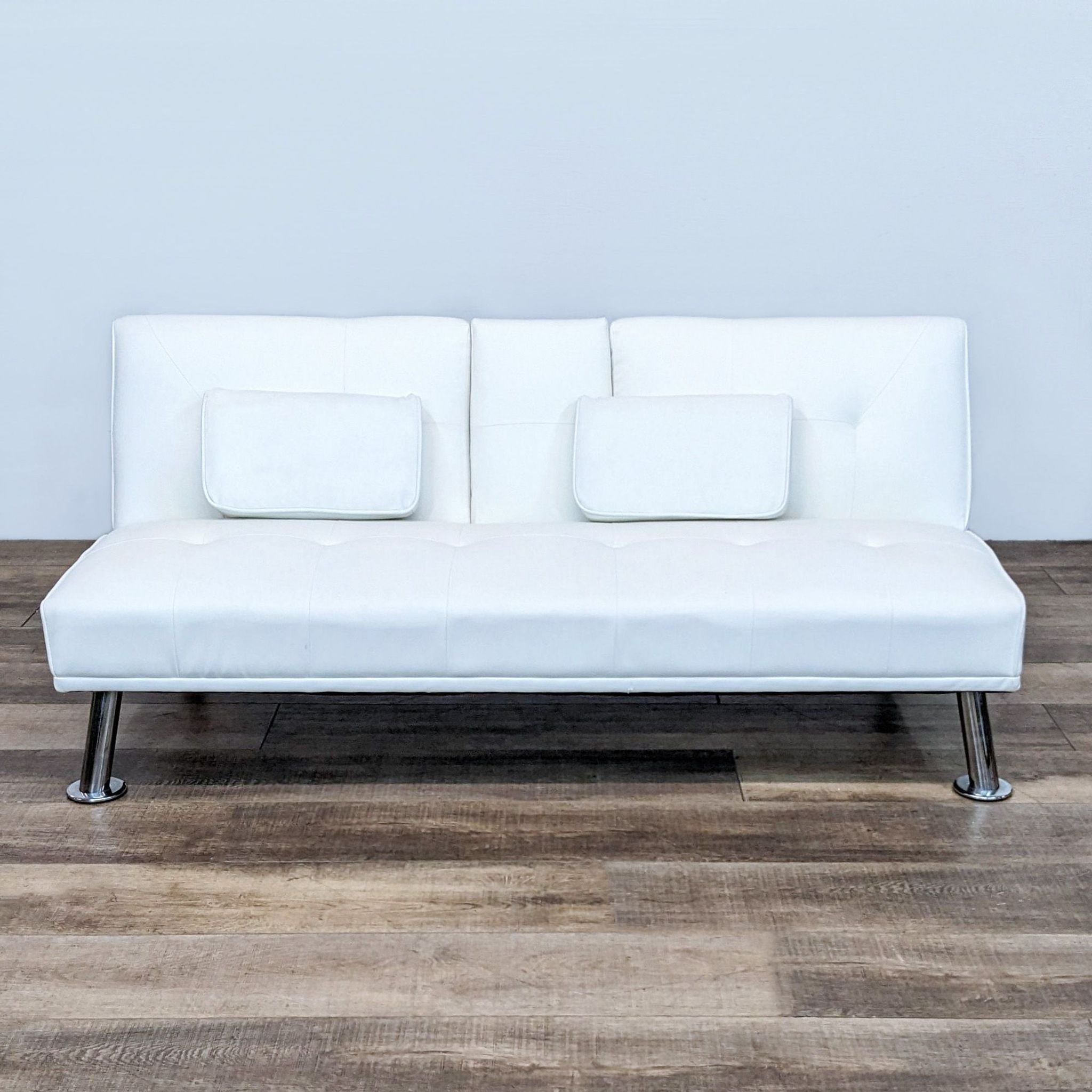 Alt text 1: White Reperch sleeper sofa in an upright position on a wooden floor against a plain backdrop.