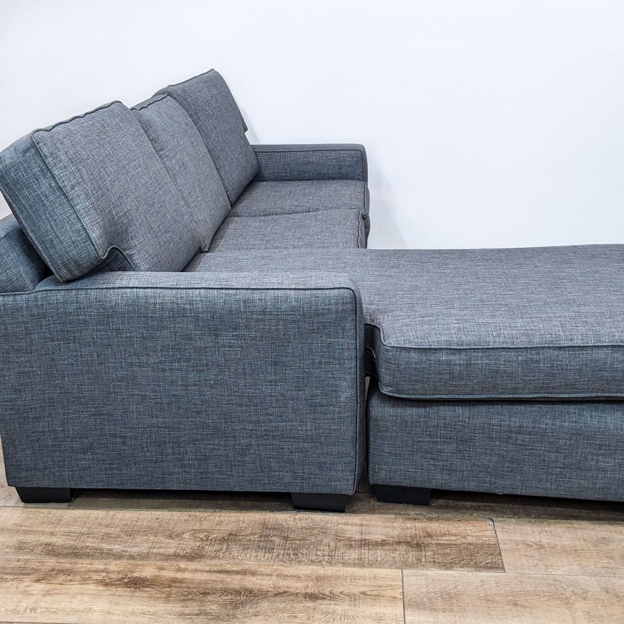 Alt text: Reperch Clean Line 94" gray sectional with reversible ottoman chaise and T-back cushions on a wood floor.
