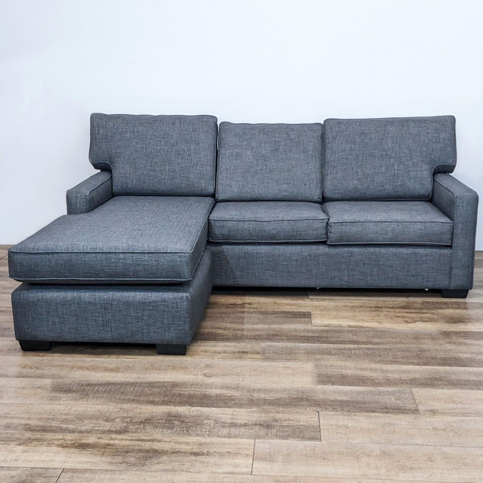 Clean Line 94" sectional by Reperch, featuring narrow arms and a reversible ottoman in a gray fabric.