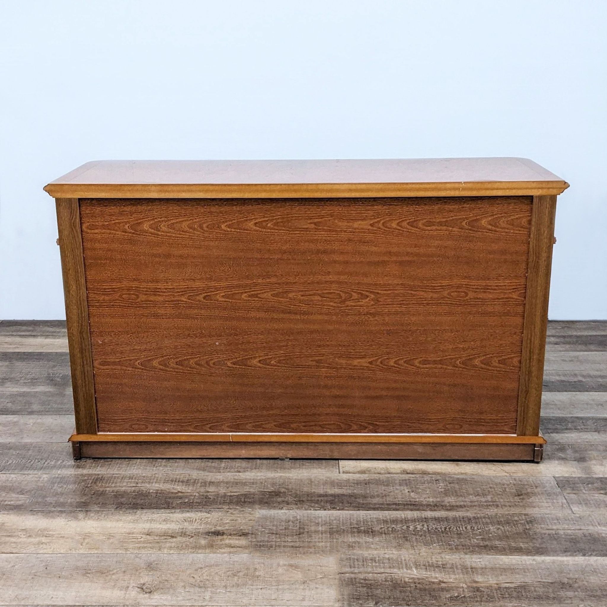 Reperch wood dresser with classic inlay detailing and eight drawers, set against a plain backdrop.
