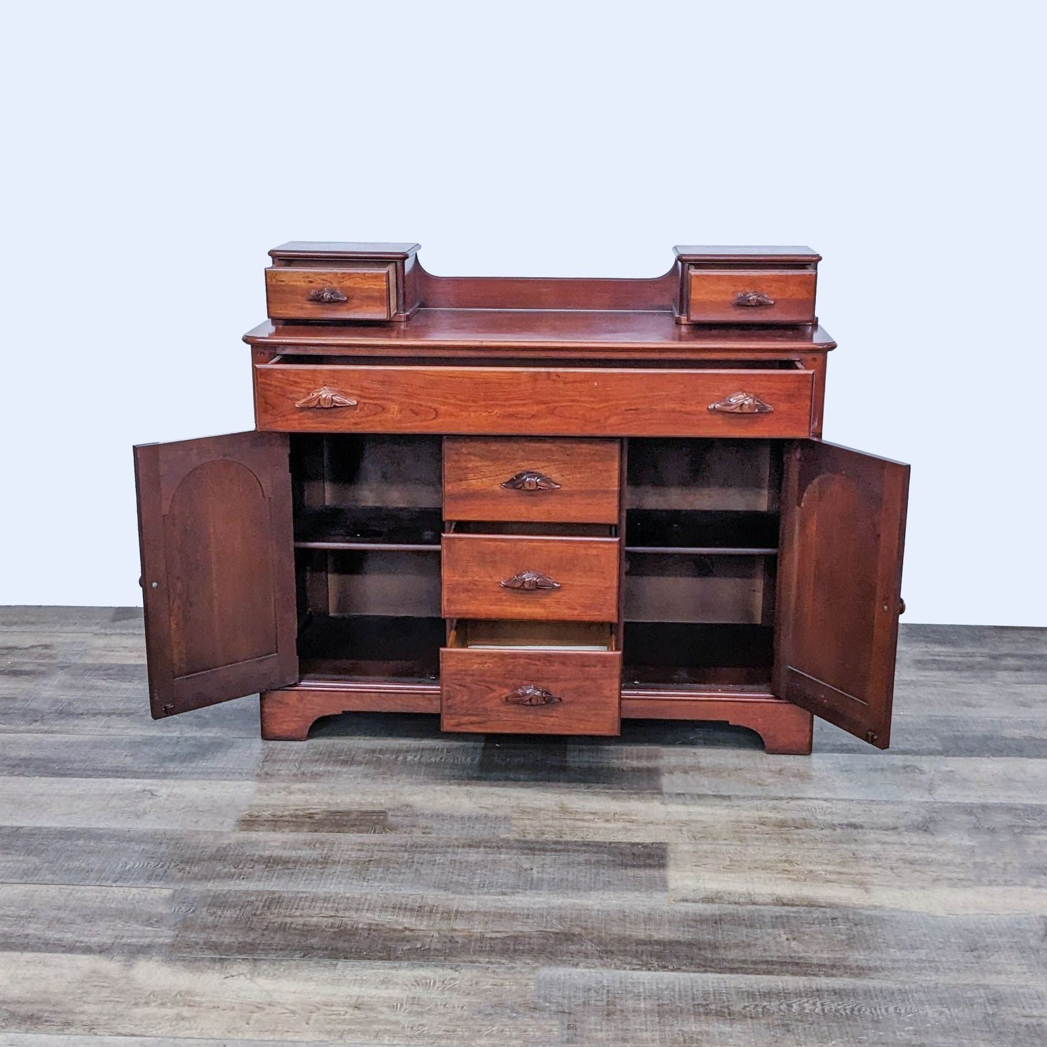 Reperch Victorian sideboard with open cabinets revealing shelving and five drawers with carved wood pulls, standing on a wooden floor.