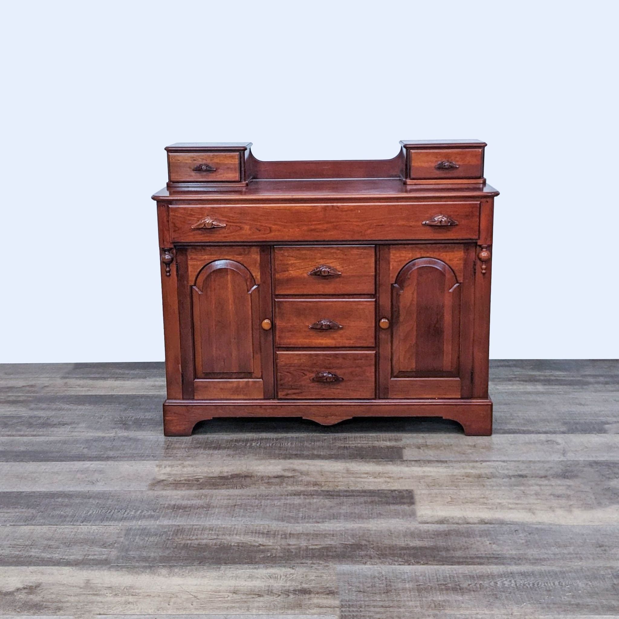 Victorian-style Reperch sideboard with two upper drawers, three centered lower drawers, and two arched cabinet doors, on a wooden floor.