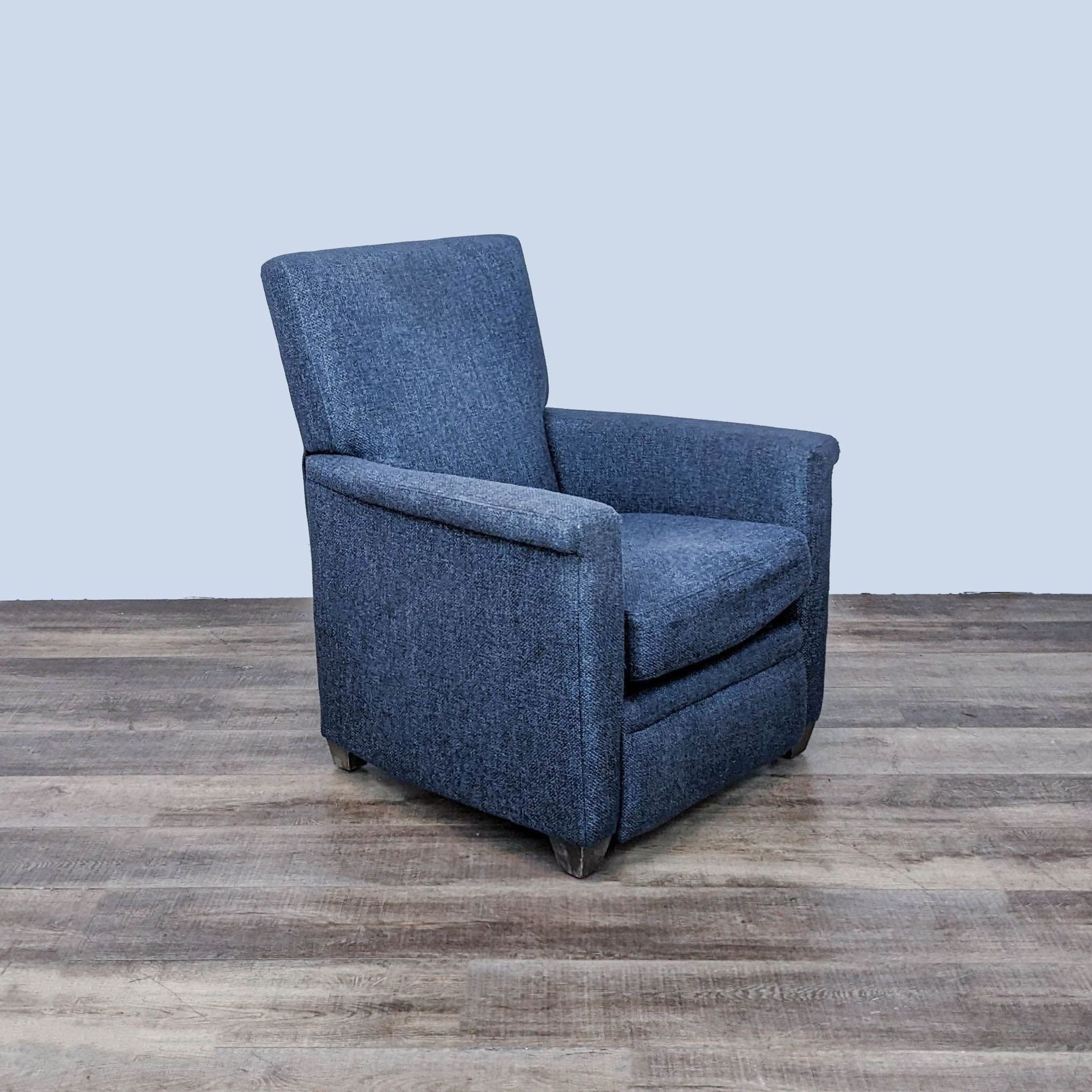 Crate & Barrel Declan manual recliner with a sturdy frame and soft blue upholstery, featuring armrests and a recline function.