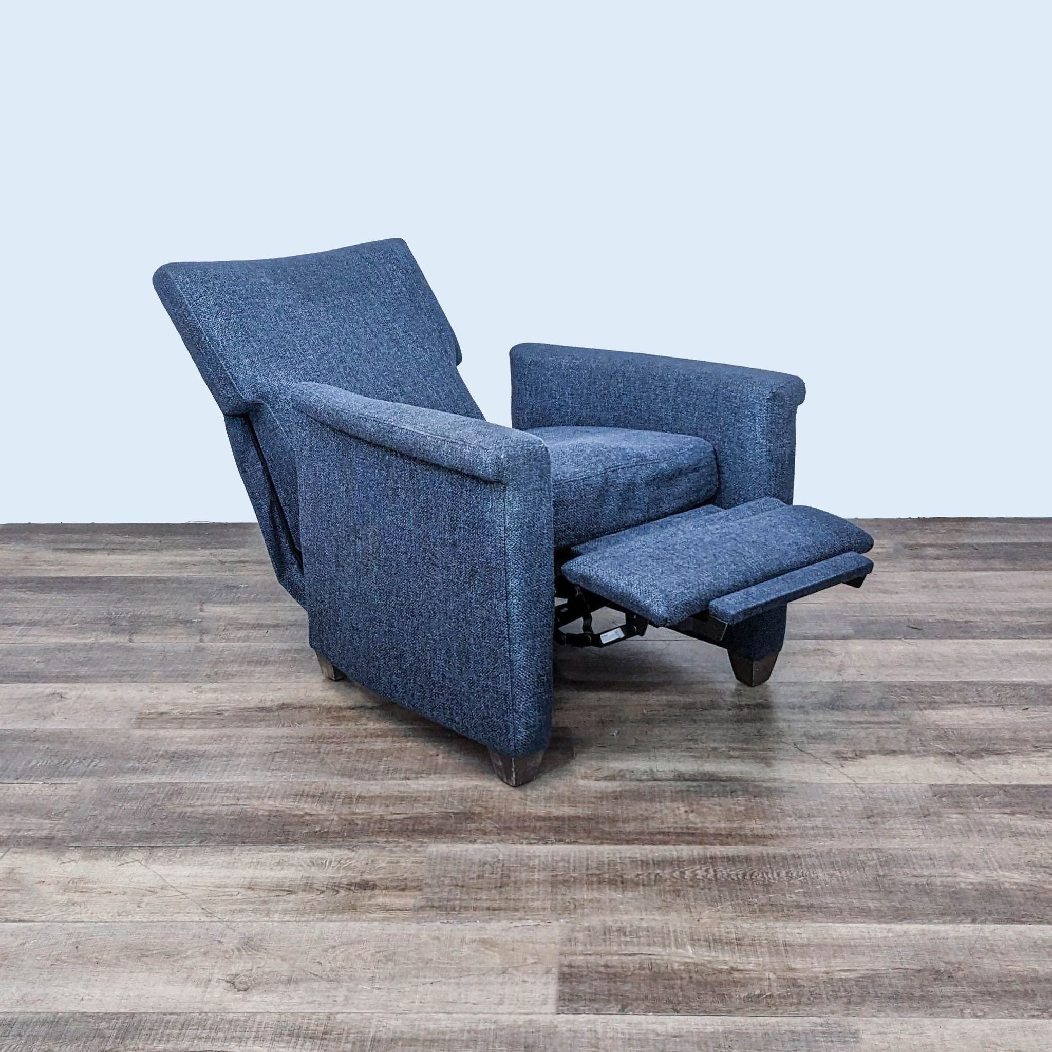 Crate & Barrel Declan lounge chair reclined on wooden floor, showcasing its manual recline function and supportive armrests.