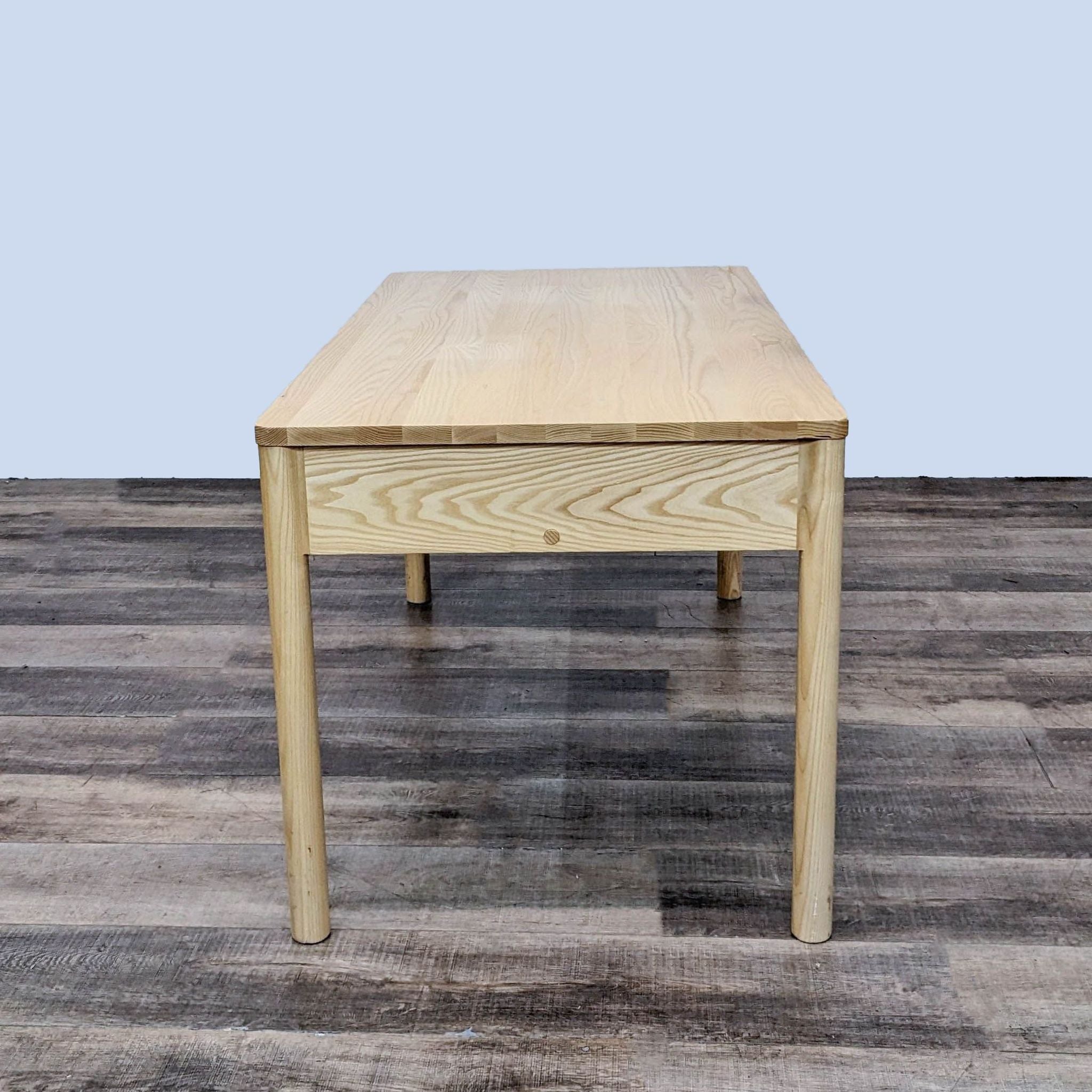 Frontal view of the MSDS Eave desk, highlighting the wood grain texture on a dark flooring background.