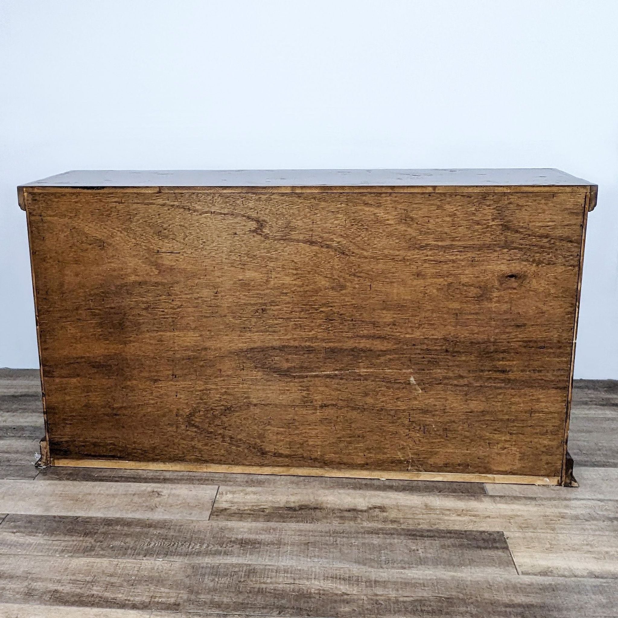 Rustic Walter of Wabash sideboard with raised panel doors and metal hardware against a wooden floor.